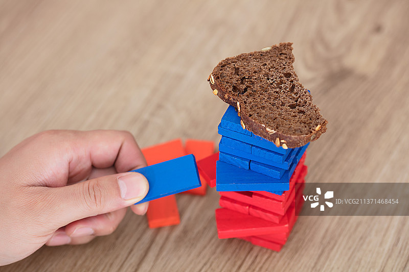 手拆掉承载面包片的积木图片素材