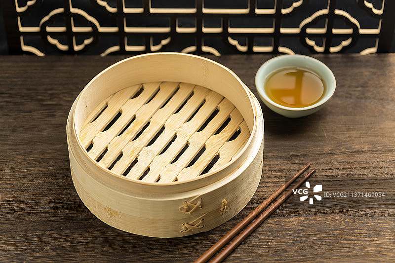 空蒸笼摆放在古窗棂木桌面上图片素材