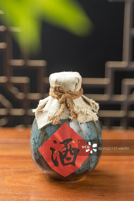 酒壶酒杯下酒菜摆放在古窗棂前的木桌面上图片素材