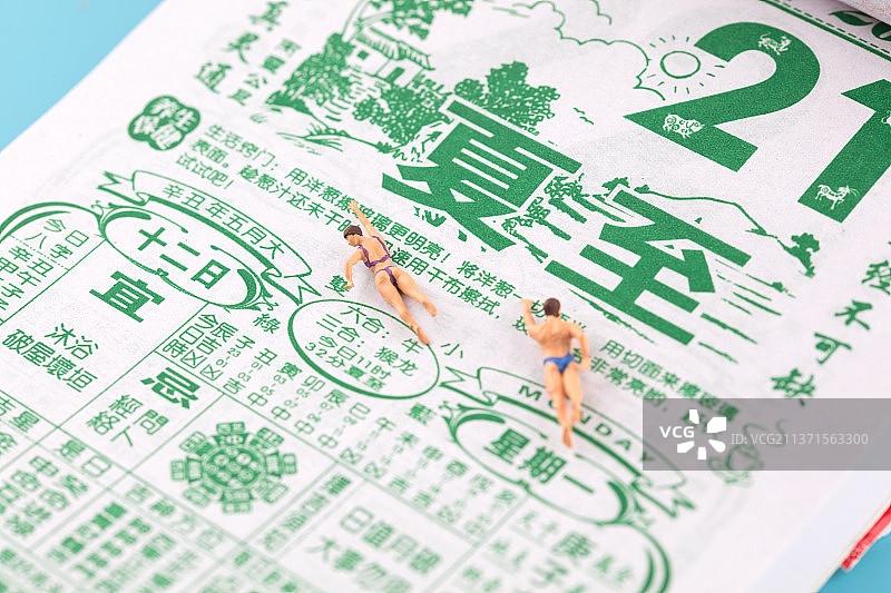 夏至时节在黄历上游泳的人偶图片素材