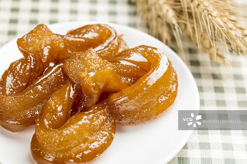 传统面食蜜麻花特写格子桌布背景图片素材