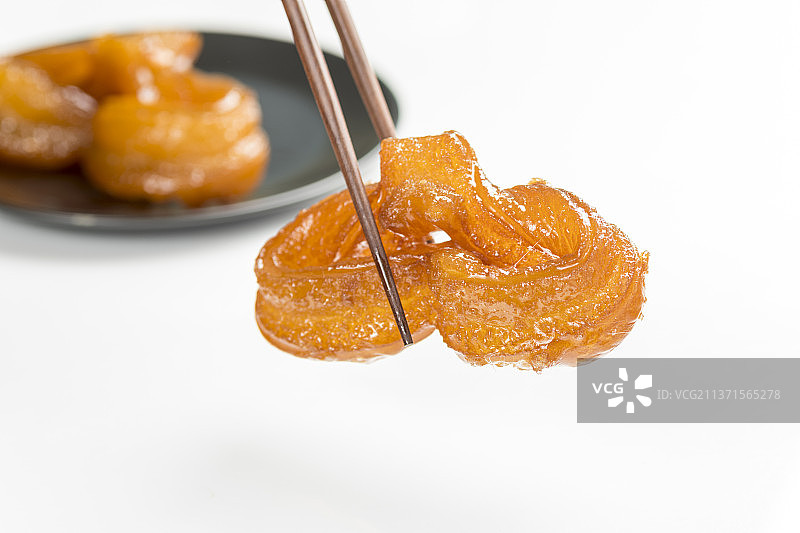 筷子夹蜜麻花特写白色背景图片素材
