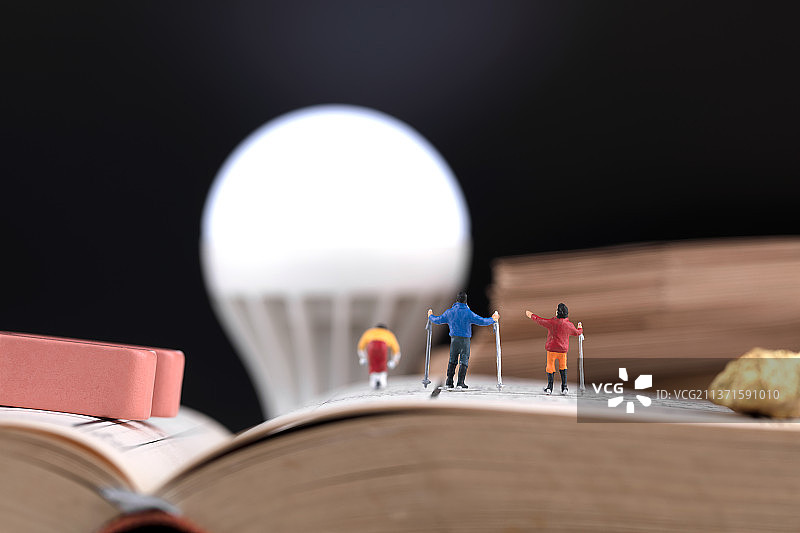 微缩创意滑雪运动员畅游在知识海洋中图片素材