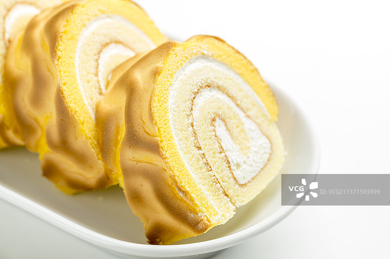 一盘虎皮卷蛋糕特写白色背景图片素材
