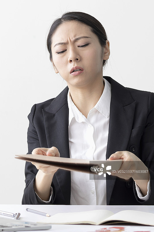 东方美女手捧着文件皱眉头图片素材