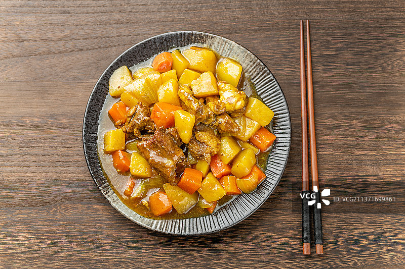 一盘咖喱牛肉特写木桌面背景图片素材