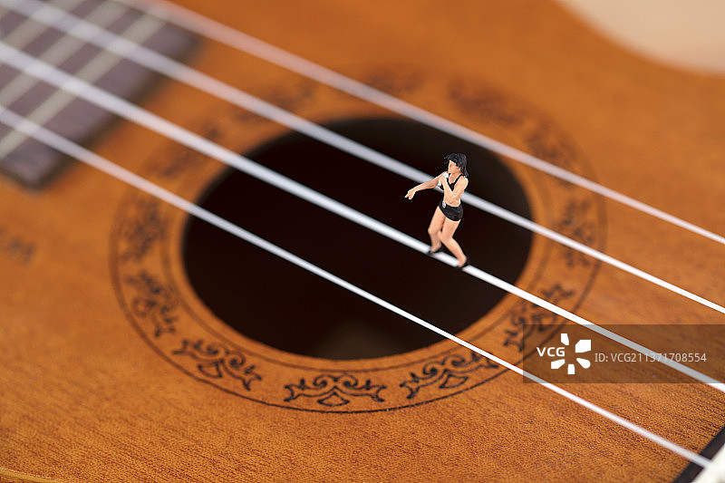 微缩创意尤克里里上玩音乐的人图片素材