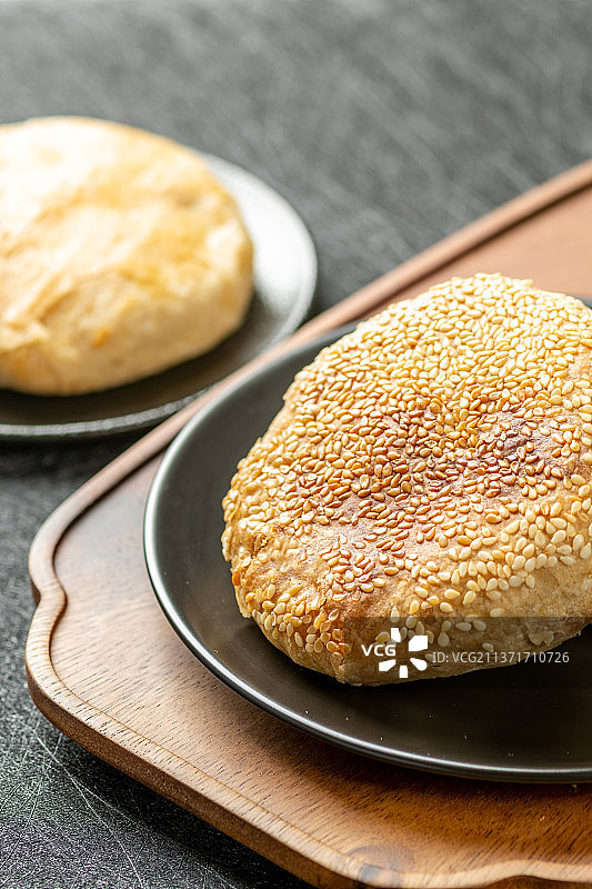 一盘芝麻烧饼特写黑色背景图片素材