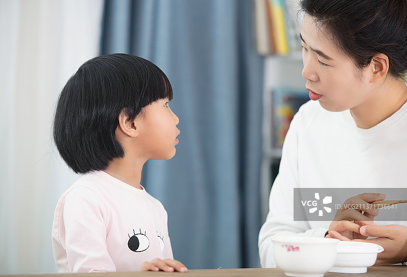 年轻妈妈喂女儿吃饭图片素材