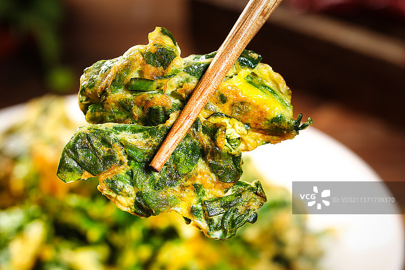 筷子上夹着荠菜炒蛋图片素材