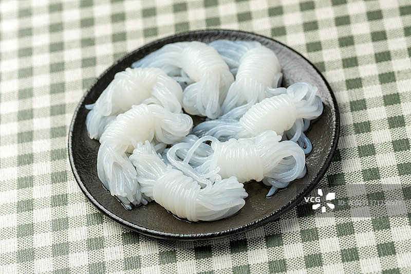 一盘魔芋摆放在格子桌布上特写图片素材