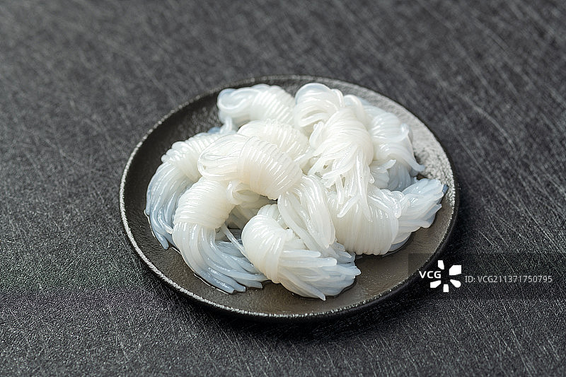 一盘魔芋摆放在黑色背景上特写图片素材