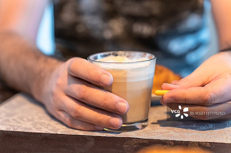 男人手持咖啡杯和药物胶囊，立陶宛图片素材