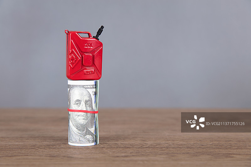 一卷美元钞票顶着汽油桶模型  汽图片素材