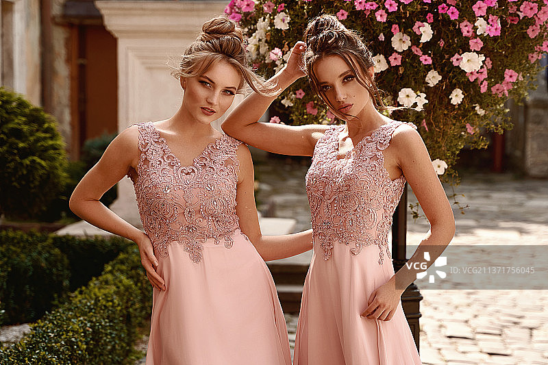 穿着粉色礼服的伴娘，站在植物前的年轻女性肖像，乌克兰图片素材