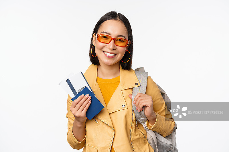 快乐的亚洲女孩度假，拿着护照和机票图片素材