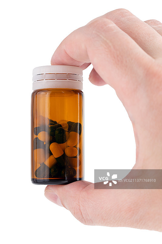 拿着装有药丸的棕色玻璃瓶的白人手图片素材