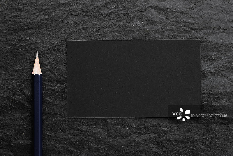 深色石材背景上的黑色卡片和铅笔图片素材