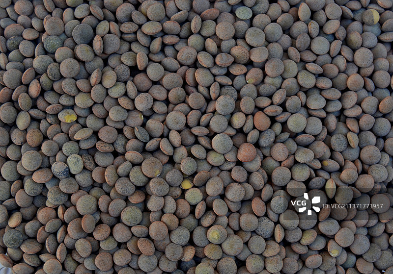 几颗未经烹饪的棕色小扁豆，在西班牙巴达霍斯市场上出售的食物的完整画面图片素材