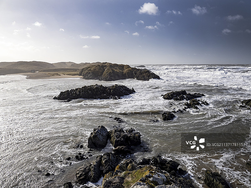 英国威尔士安格尔西岛纽堡，狂风巨浪涌向兰德温岛图片素材