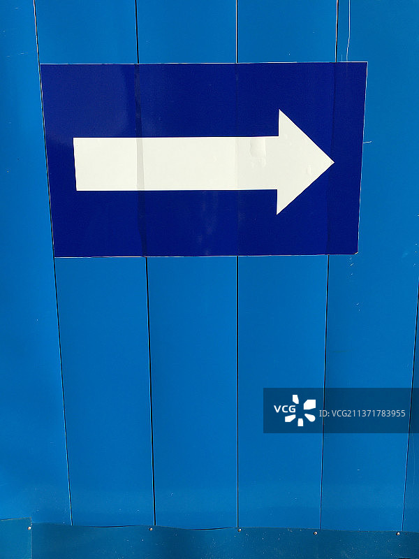 带有白色箭头的蓝色墙壁特写图片素材