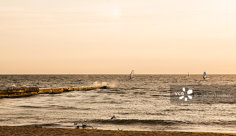 日出时分乌克兰敖德萨海上的风帆冲浪者剪影图片素材