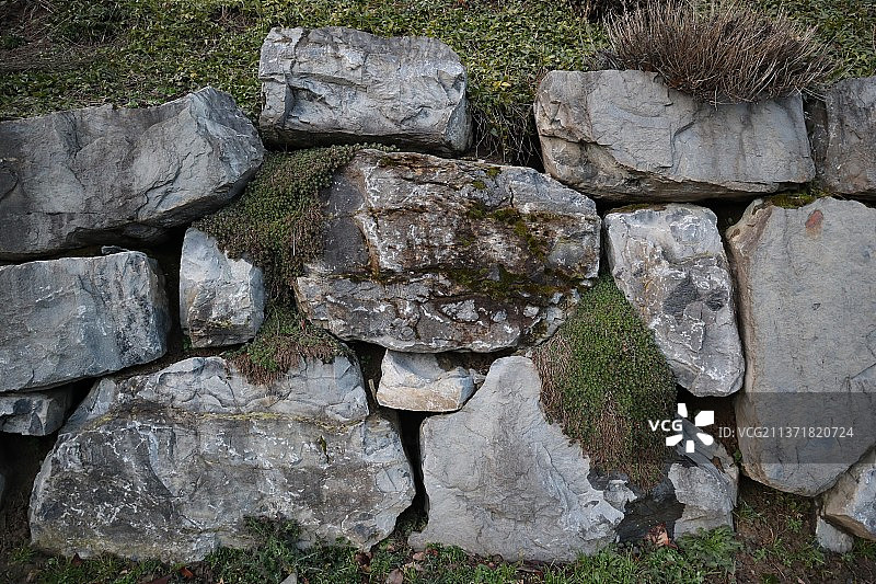 苔藓石墙，高角度俯瞰草地岩石，瑞士埃帕兰热图片素材