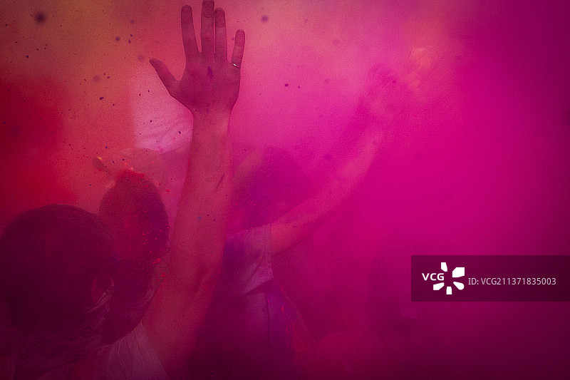 在彩色粉色烟雾中跳舞的人们图片素材