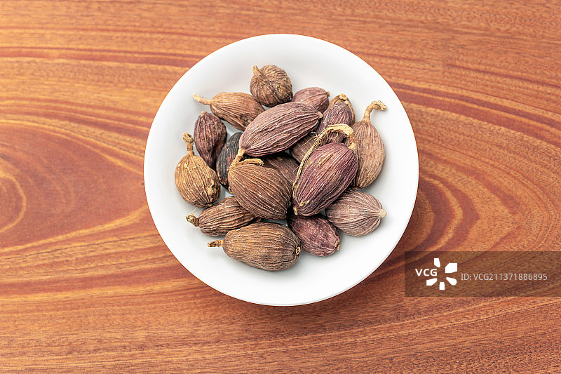 药食两用中药材调料香料草果摆放在木桌面上图片素材