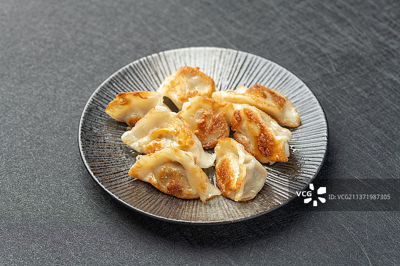 一盘煎饺子特写黑色背景图片素材