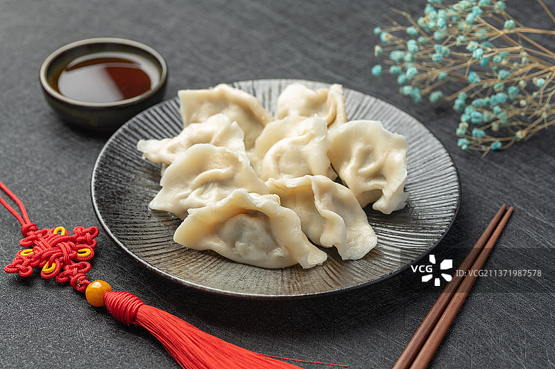 一盘水饺摆放在黑色背景上中国风图片素材