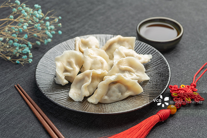 一盘水饺摆放在黑色背景上中国风图片素材