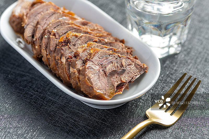 一盘酱牛肉切片特写黑色背景图片素材