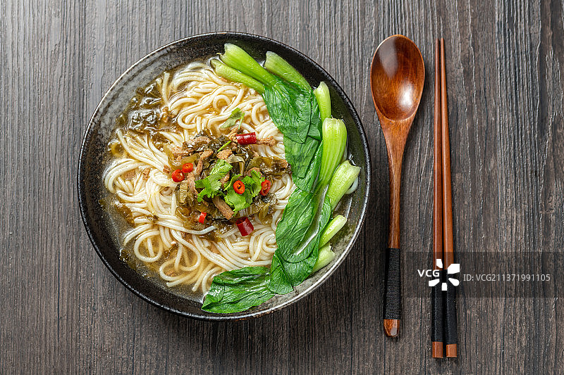 一碗酸菜肉丝米线摆放在木桌面上特写图片素材