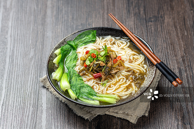 一碗酸菜肉丝米线摆放在木桌面上特写图片素材