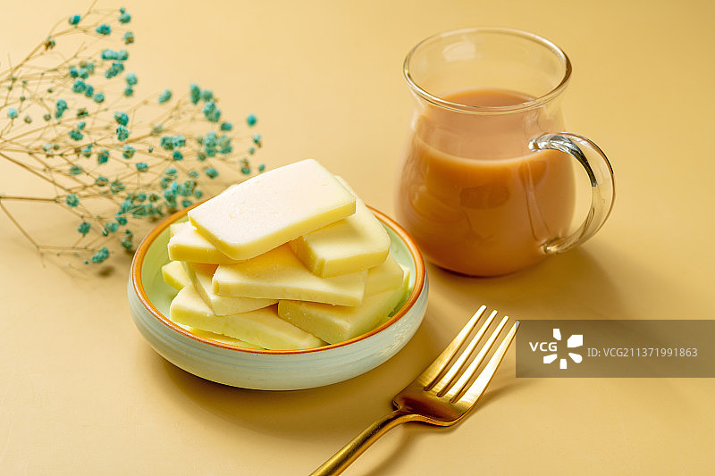 一盘奶豆腐摆放在黄色背景上图片素材