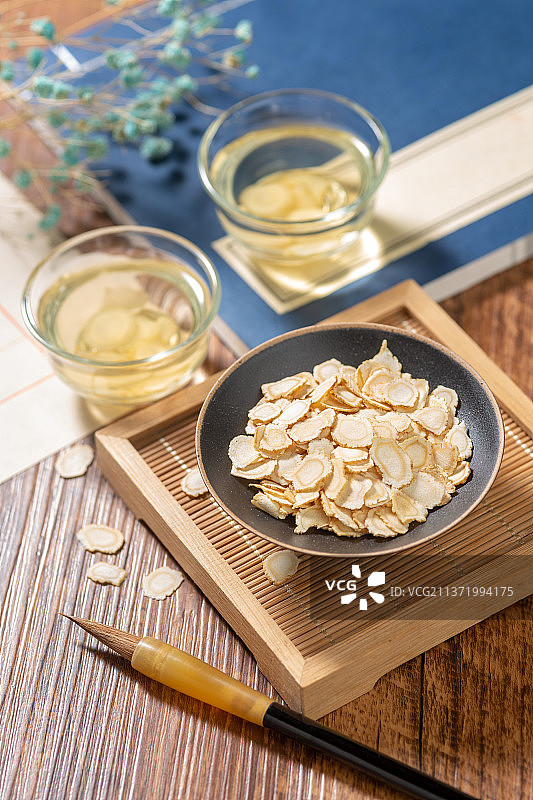 西洋参摆放在木桌面背景上特写图片素材