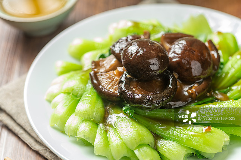 一盘香菇油菜摆放在木桌面上图片素材