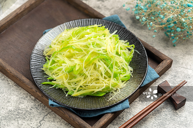 一盘尖椒土豆丝摆放在水泥桌面上特写图片素材