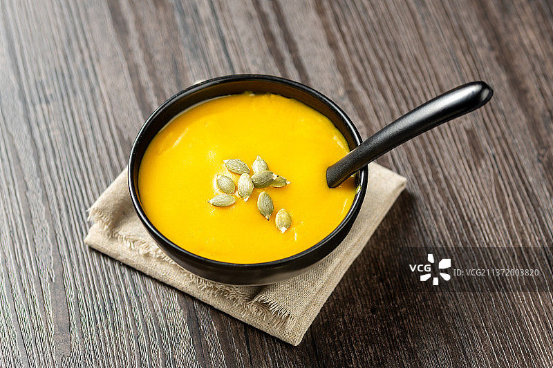 一碗小米南瓜粥特写木桌面背景图片素材