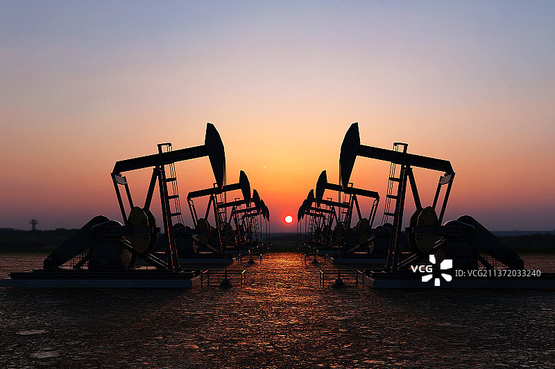 剪影石油油开采机在日落与地平线炽热光线的照射下图片素材