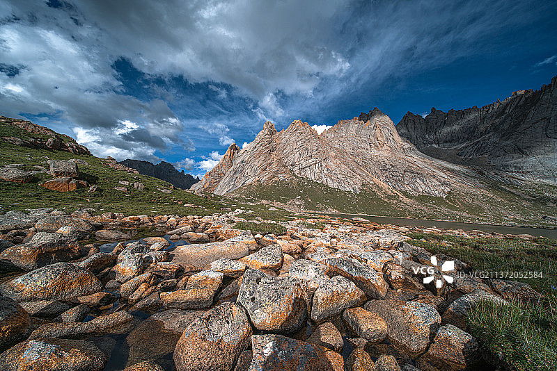 多云天气山峰下的草坪图片素材