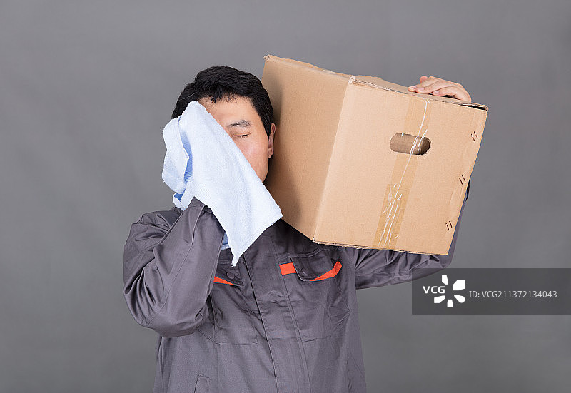 辛苦的快递员在搬运包裹图片素材