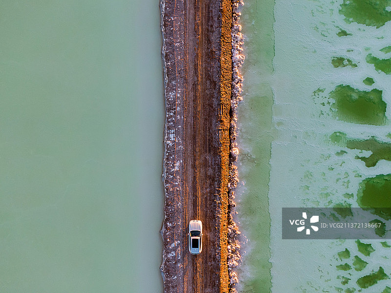 夕阳中的茫崖翡翠湖路中间一辆车通过可能是宝马X3 也可能识别的车图片素材