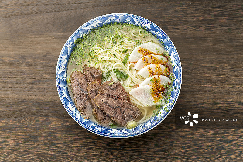 一碗兰州牛肉拉面摆放在木桌面上图片素材