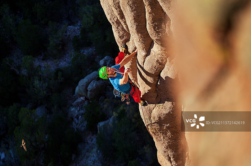 在科罗拉多州悬垂巨岩墙上的男攀岩者图片素材