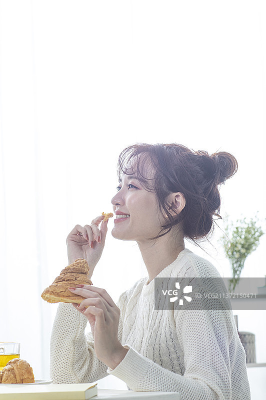 东方美女坐着吃面包图片素材