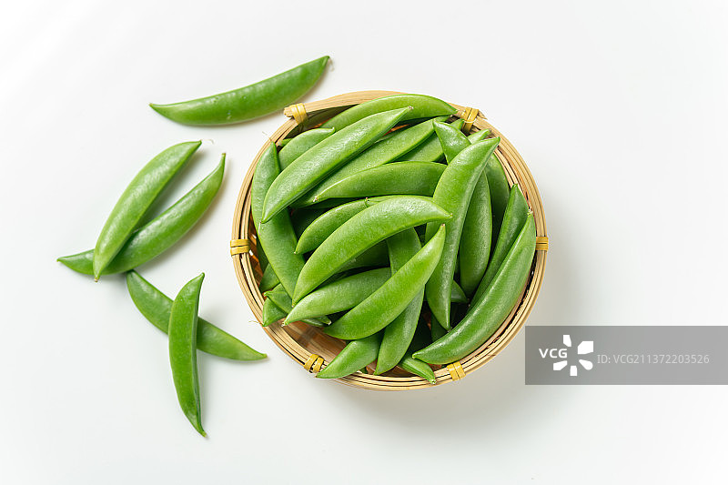一簸箕甜豆摆放在白色背景上图片素材