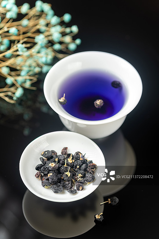 黑枸杞与黑枸杞茶摆放在黑色背景上图片素材