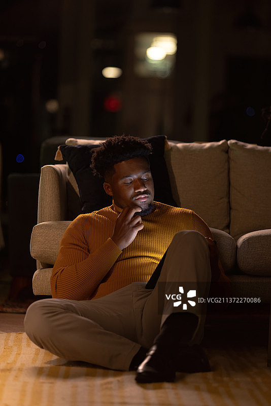 男人坐在客厅的地板上使用平板电脑图片素材